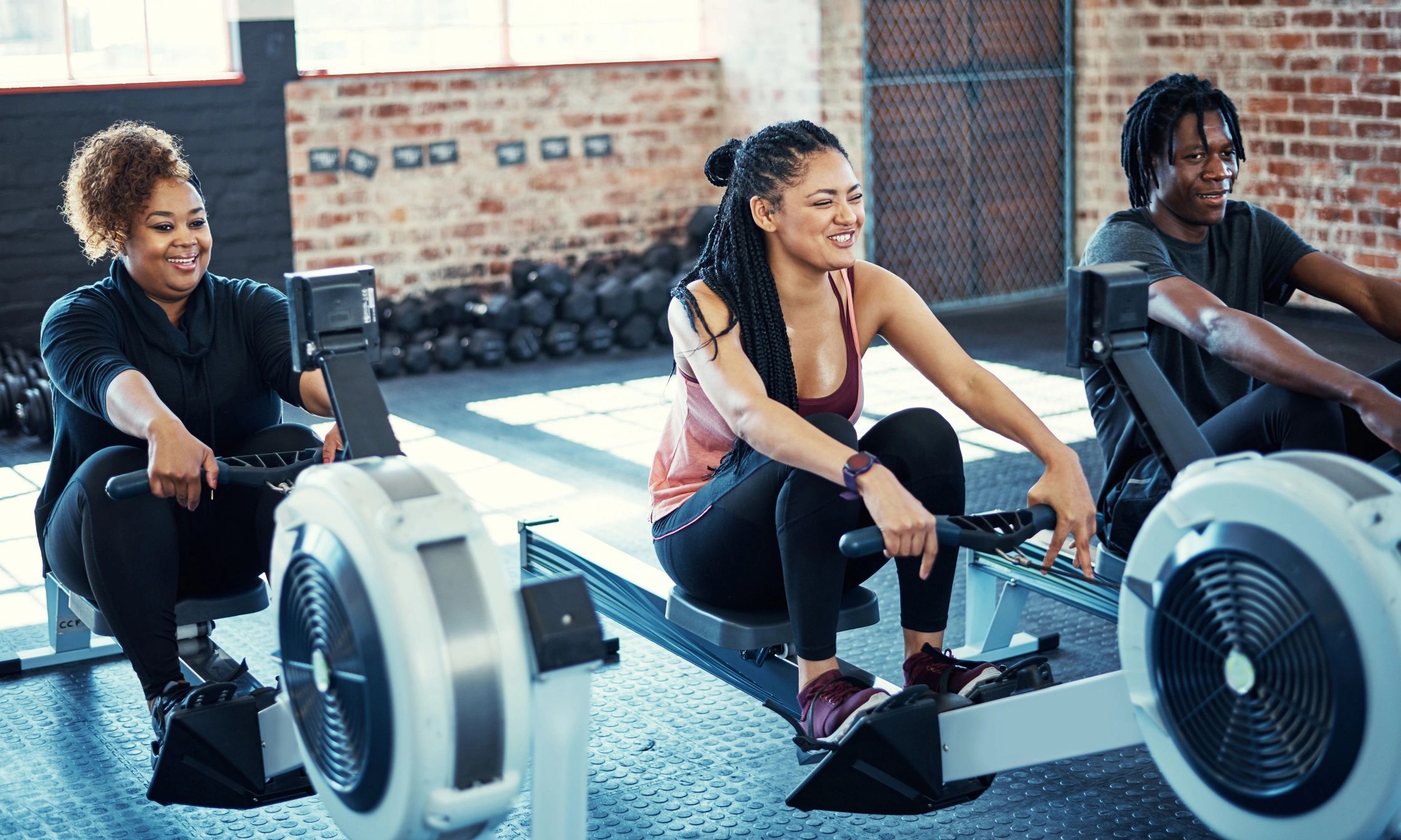 Fitness group training together on rowing machines